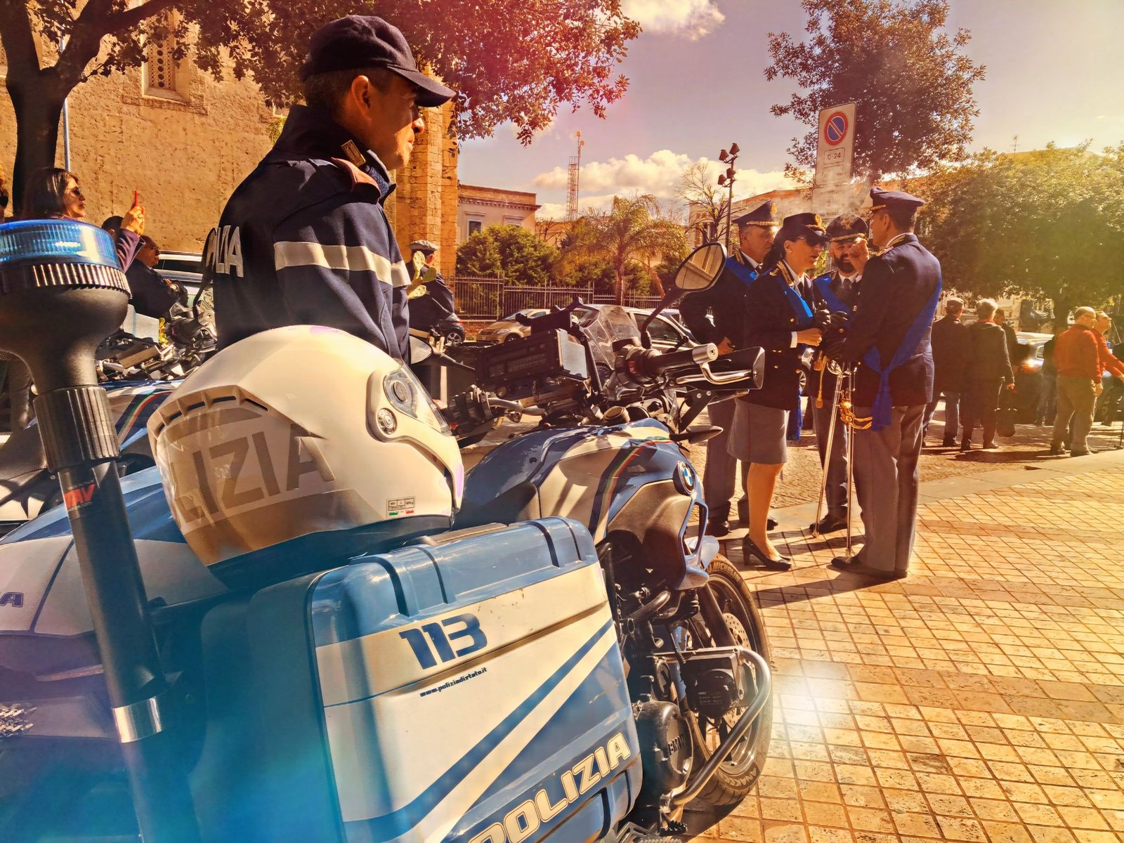 Moto polizia in 1° piano e agentti in divisa festa