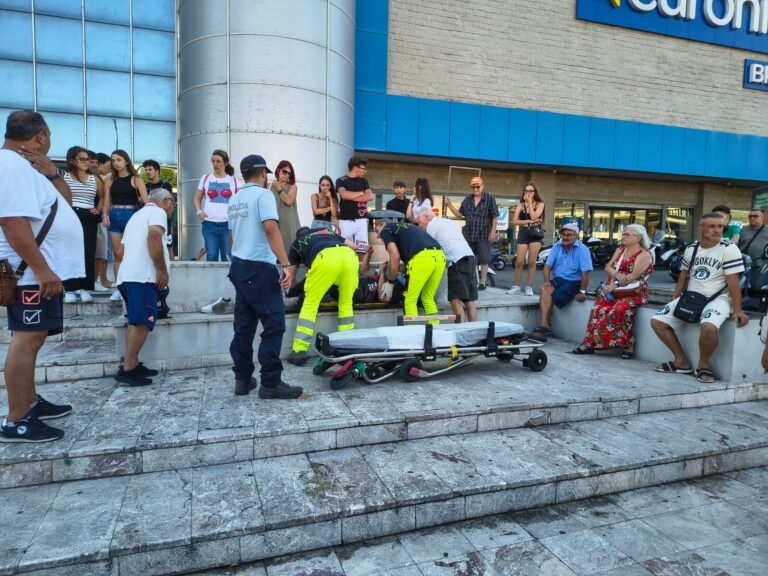 Scontro tra scooter e bici elettrica davanti al centro commerciale: due feriti